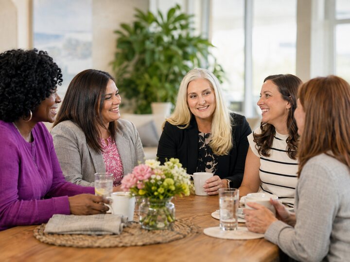 Women laughing and building business relationships through conversation.